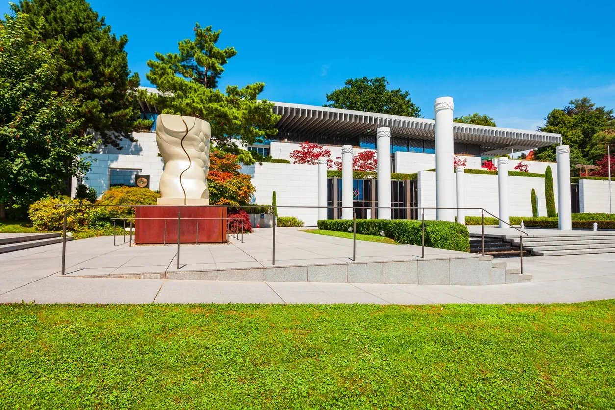 Exterior del Museo Olímpico de Lausanne, con una escultura y columnas blancas frente al edificio